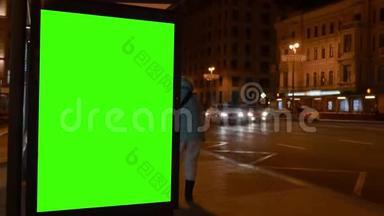 市街。 晚上好。 展示用大的绿色屏幕。 汽车来了。